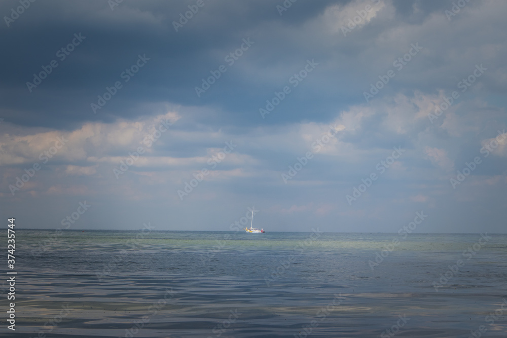 sailing boat in the sea against the background of storm clouds sailing boat in the sea against the background of storm clouds