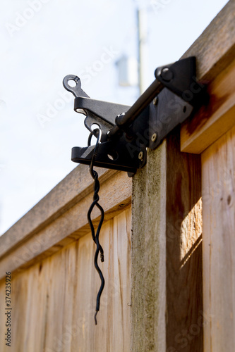 A twisted wire secures a gate as a deterrent; A gate latched and locked with a wire photo