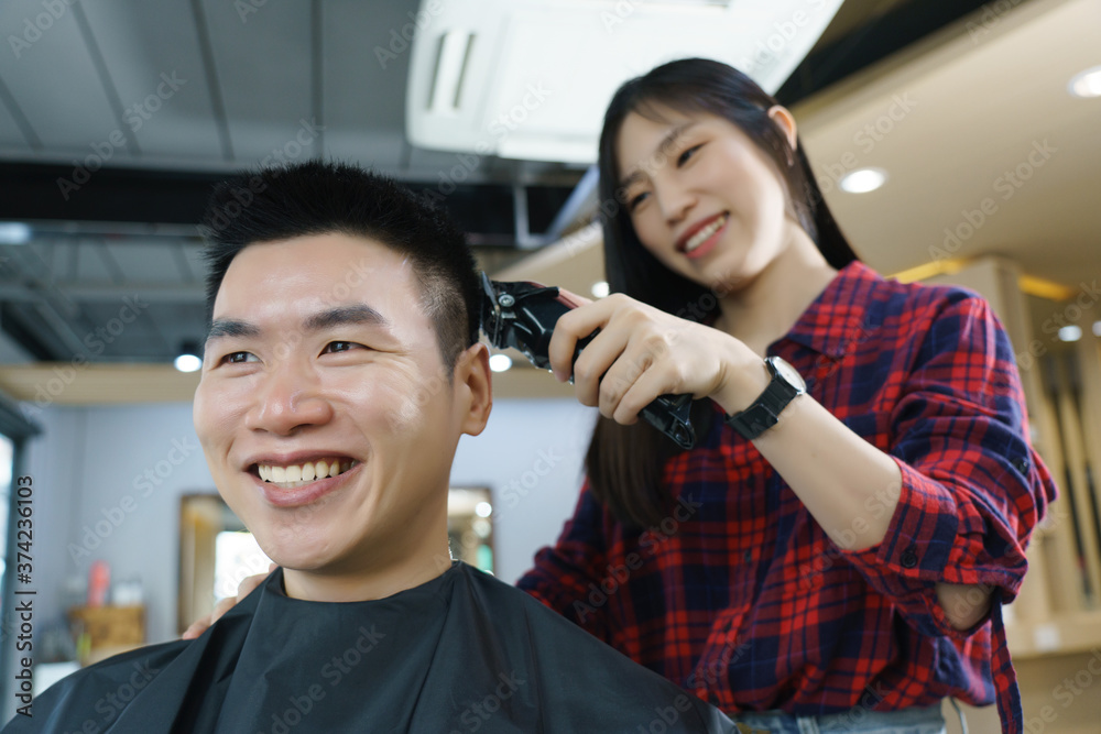 Happy Asian man use the haircut service in Barber shop. Woman hairdresser  provide service mind. Hairdressing equipment is clean. End of quarantine  and return to open salon hair work Stock Photo |