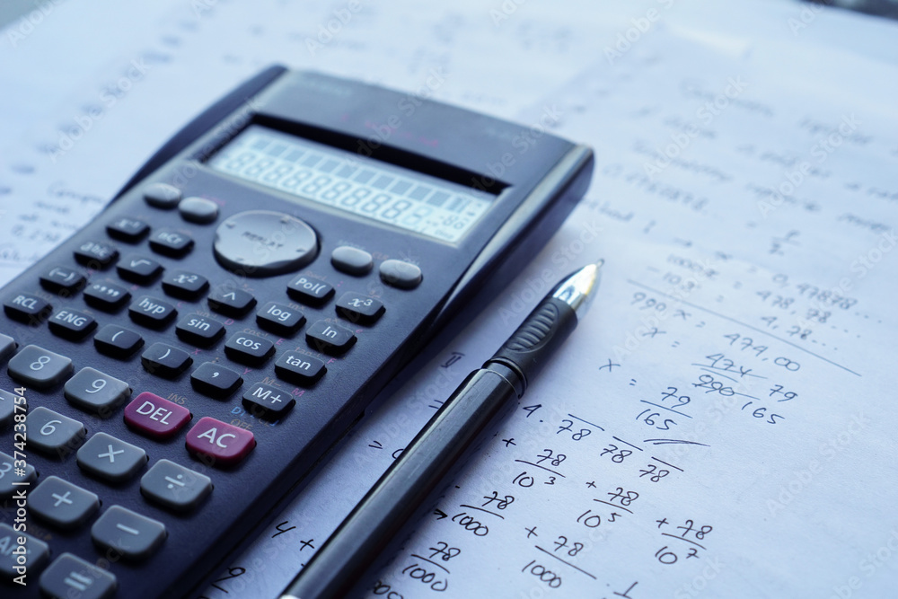 scientific math workout. sheet paper with solving equation math next to calculator scientific math workout. sheet paper with solving equation math next to calculator