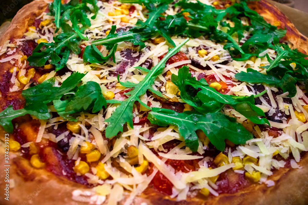 Pizza with fresh green arugula, parmesan cheese and cherry tomatoes food background. Freshly baked homemade pizza Pizza with fresh green arugula, parmesan cheese and cherry tomatoes food background. Freshly baked homemade pizza