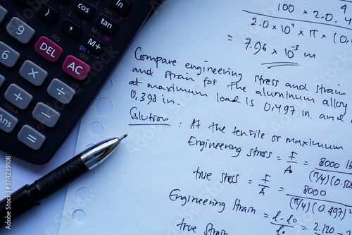 scientific math workout. sheet paper with solving equation math next to calculator