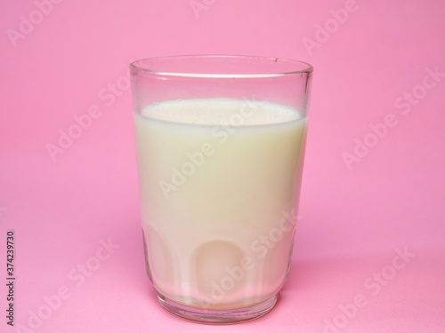 A glass of milk isolated on pink background. Fresh milk