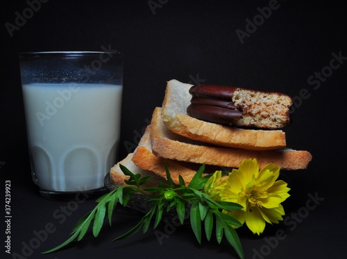 Dry rusk bread and a glass of milk isolated on black background. Healhty breakfast menu
