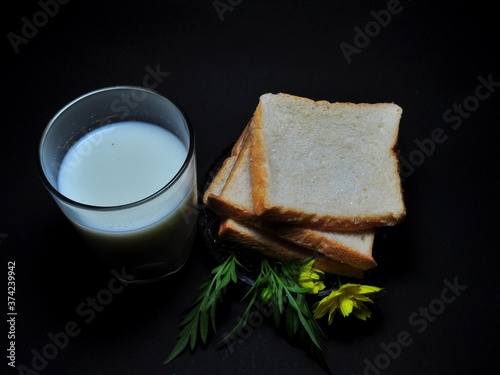 Dry rusk bread and a glass of milk isolated on black background. Healhty breakfast menu