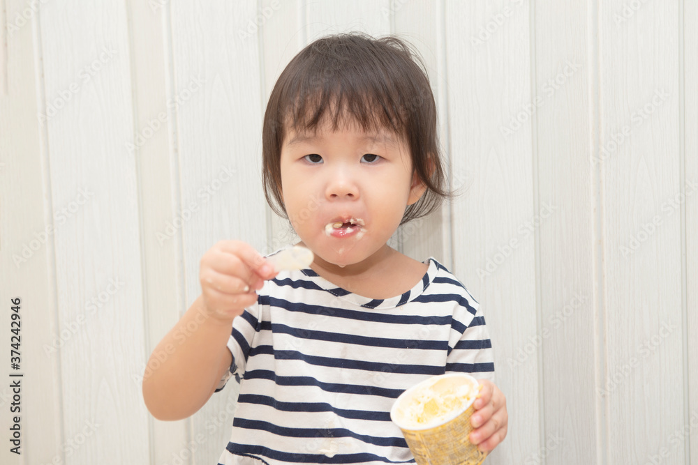Asian cute toddler girl enjoying her ice cream at home. Asian cute toddler girl enjoying her ice cream at home.
