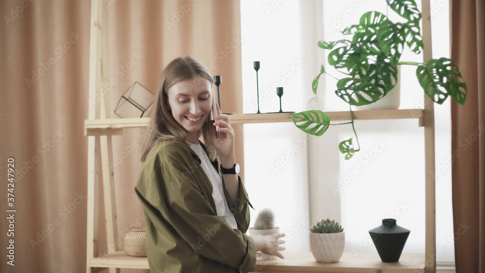 Attractive woman talks on the phone and check her cactus Attractive woman talks on the phone and check her cactus