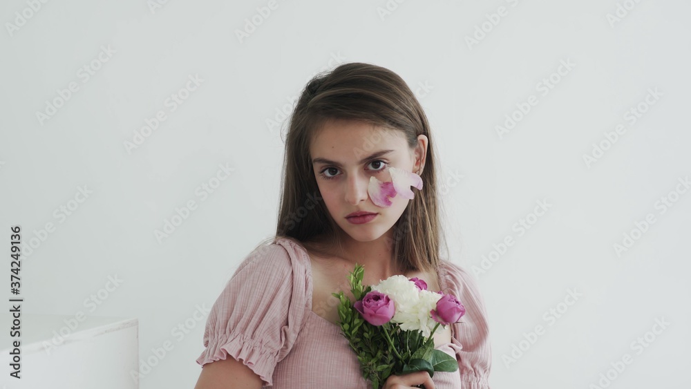 Professional young woman model with flowers looking and posing at camera Professional young woman model with flowers looking and posing at camera