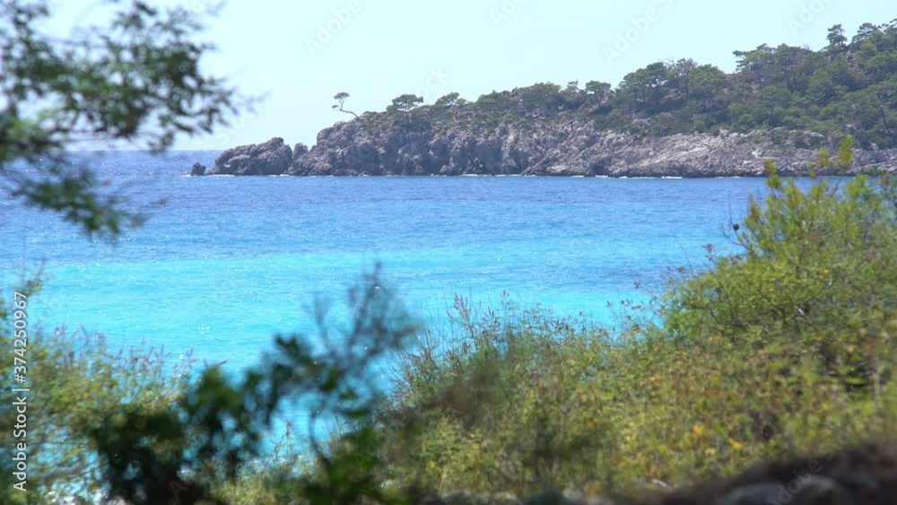Turquoise Mediterranean sea from behind trees