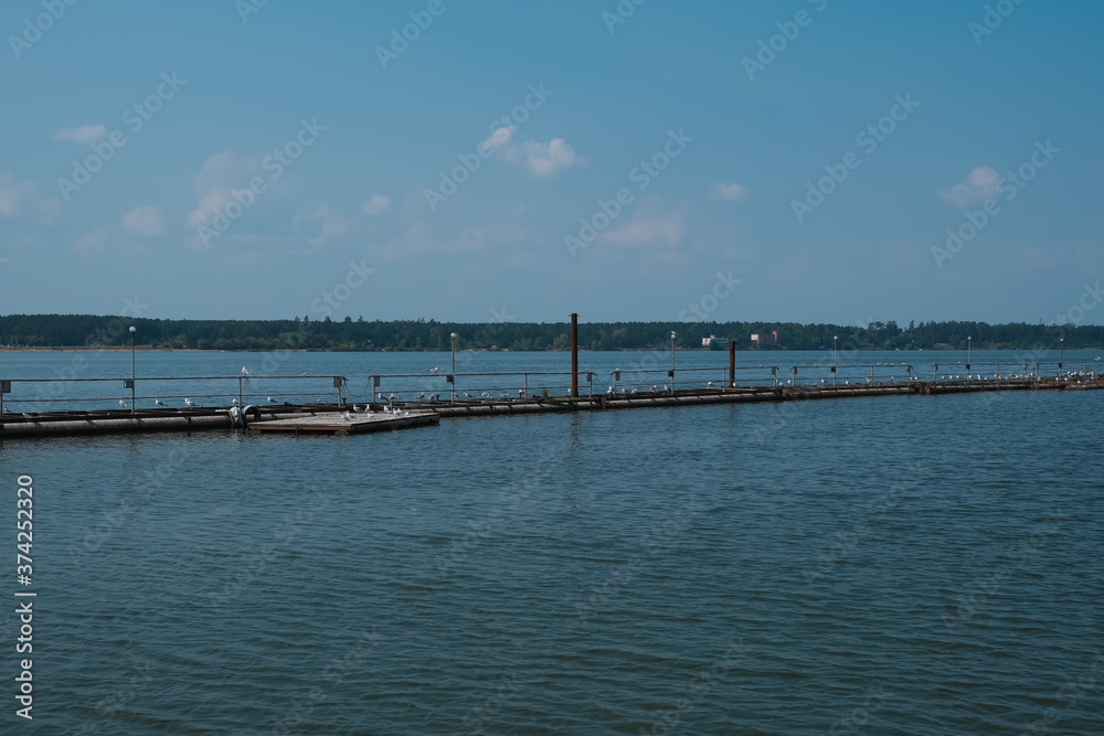 sea pier with seagulls, blue sea and sky