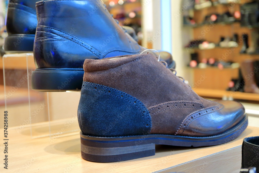 Fashionable men's shoes are on the shelf of the store.