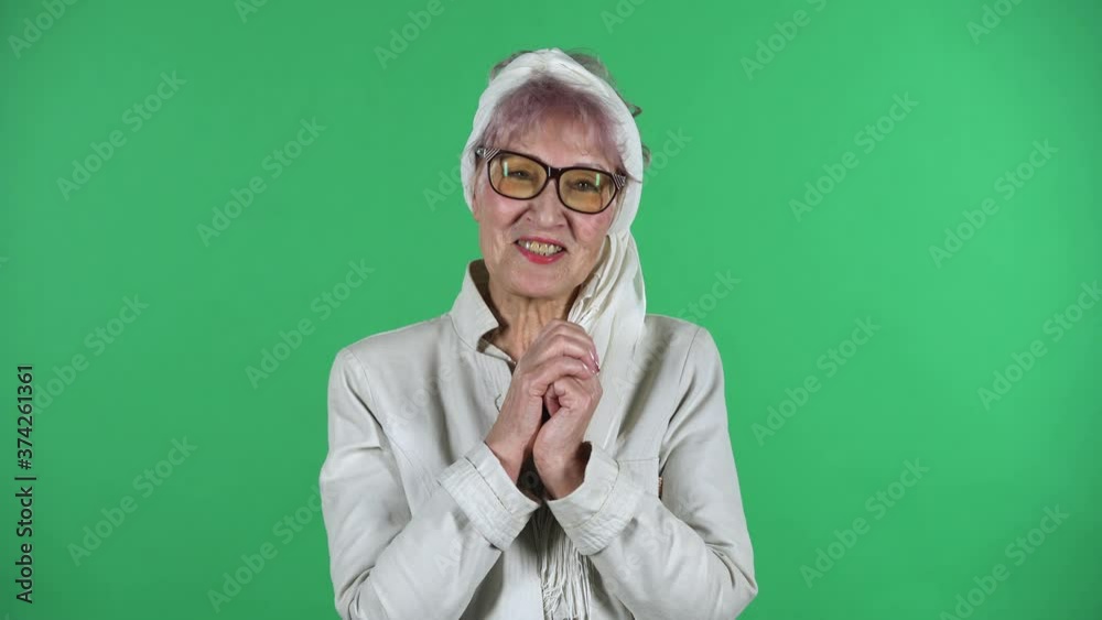 Portrait of old stylish woman is communicates with someone in a friendly manner isolated over green background. Portrait of old stylish woman is communicates with someone in a friendly manner isolated over green background.