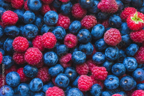lots of fresh raspberries and blueberries - food background