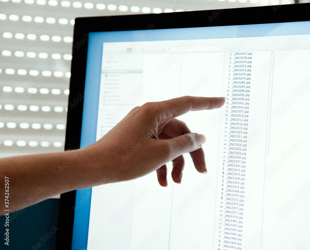 An index finger pointing at monitor. An index finger pointing at monitor.