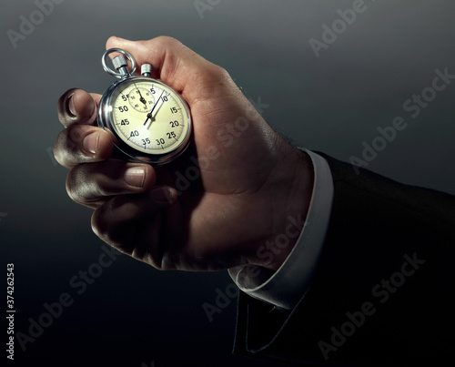 A business hand holding stop watch in color.