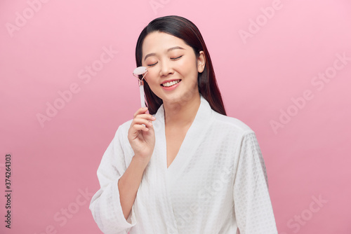 Woman uses jade roller for facial massage