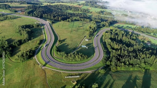 Poland. Winding switchback road from Krakow to Zakopane, called Zakopianka, near Rabka and Chabowka. Aerial video in sunrise light with morning fog.  photo