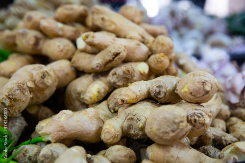 Fresh ginger root on showcase of greengrocery shop for sale to customers. High quality photo