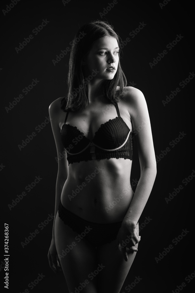 Vertical view photo beautiful shy lady in lace bikini boudoir bra panties. Tender skinny slim shape isolated black background. Vertical view photo beautiful shy lady in lace bikini boudoir bra panties. Tender skinny slim shape isolated black background.