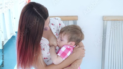 Mom breastfeeds her son on board