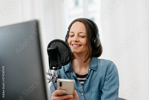 Fotografija Woman recording a podcast on her computer