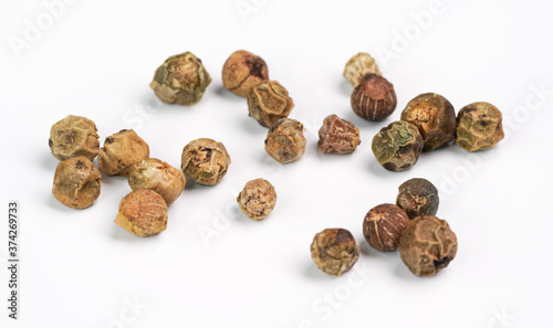 Dry green peppercorns isolated on white background board, closeup view