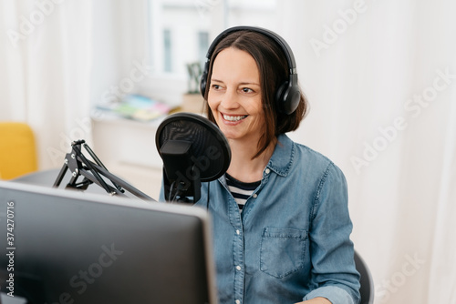 Smiling middle-aged woman recording a podcast