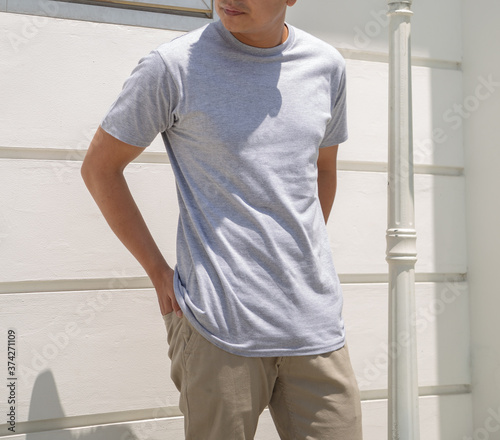 Young handsome man wearing heather grey t shirt short sleeve was posing at outdoor