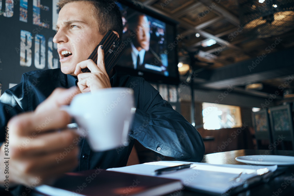 Business man with a cup of coffee in a cafe emotions work in the office stress irritability director Business man with a cup of coffee in a cafe emotions work in the office stress irritability director