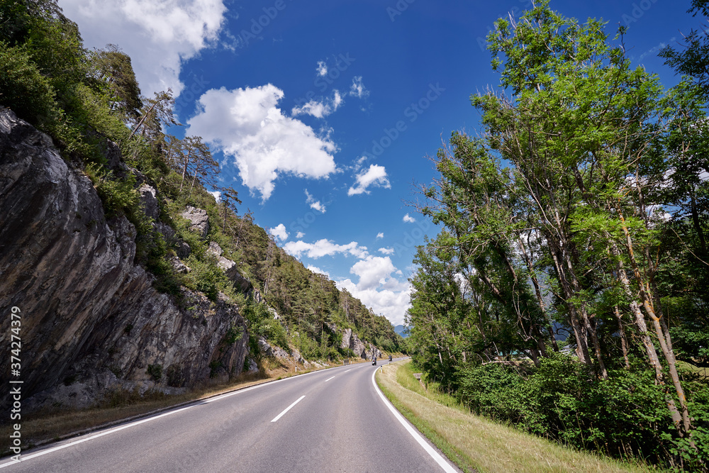 Fototapeta premium Asphalt road in Alps mountains. Trip concept.