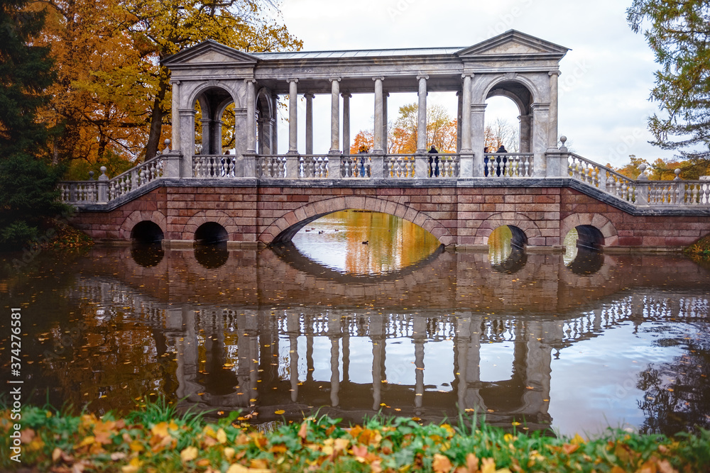 Obraz premium The bridge and autumn forest lake.