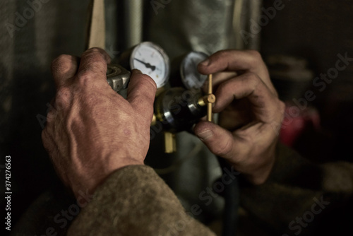 Hands of a man who works with a pressure gauge in the garage.