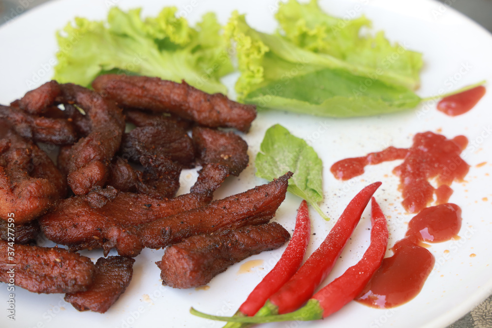 Crispy fried pork cutlets and red chillies are placed on the plate.