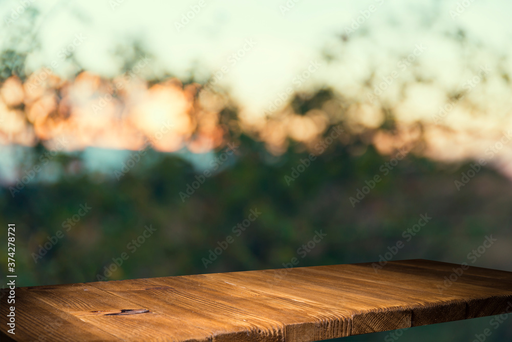 Empty wooden deck table with foliage bokeh background. Ready for product display montage. Empty wooden deck table with foliage bokeh background. Ready for product display montage.