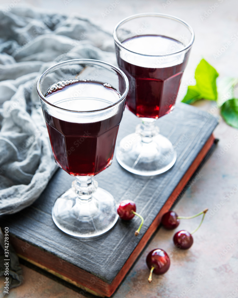 Cherry liqueur in a glass and fresh fruits Cherry liqueur in a glass and fresh fruits