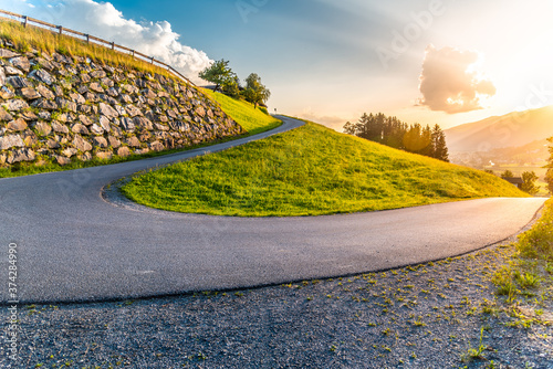 Sharp hairpin curve of narrow rural asphalt road in the mountains. Austrian Alps, Austria