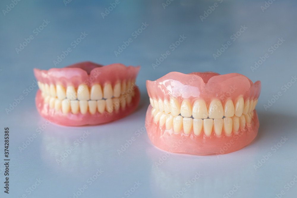 The dentures of the two elderly people were placed on a shiny white table. The dentures of the two elderly people were placed on a shiny white table.