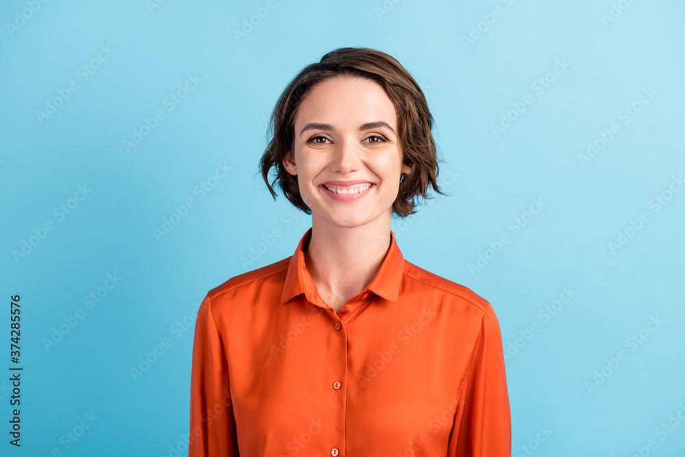 Closeup photo of attractive amazing pretty business lady bob hairdo good mood smiling white teeth charming cute appearance wear orange office shirt isolated blue pastel color background Closeup photo of attractive amazing pretty business lady bob hairdo good mood smiling white teeth charming cute appearance wear orange office shirt isolated blue pastel color background