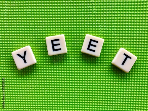 ‘Yeet’ slogan formed by separate letter stones on a bright green background. It’s a popular internet culture phrase. photo