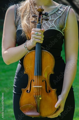 Obraz na płótnie The girl is holding a violin. Brown violin in hands background. w salonie
