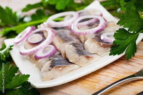 Mediterranean herring fillet served with sliced onion rings and parsley