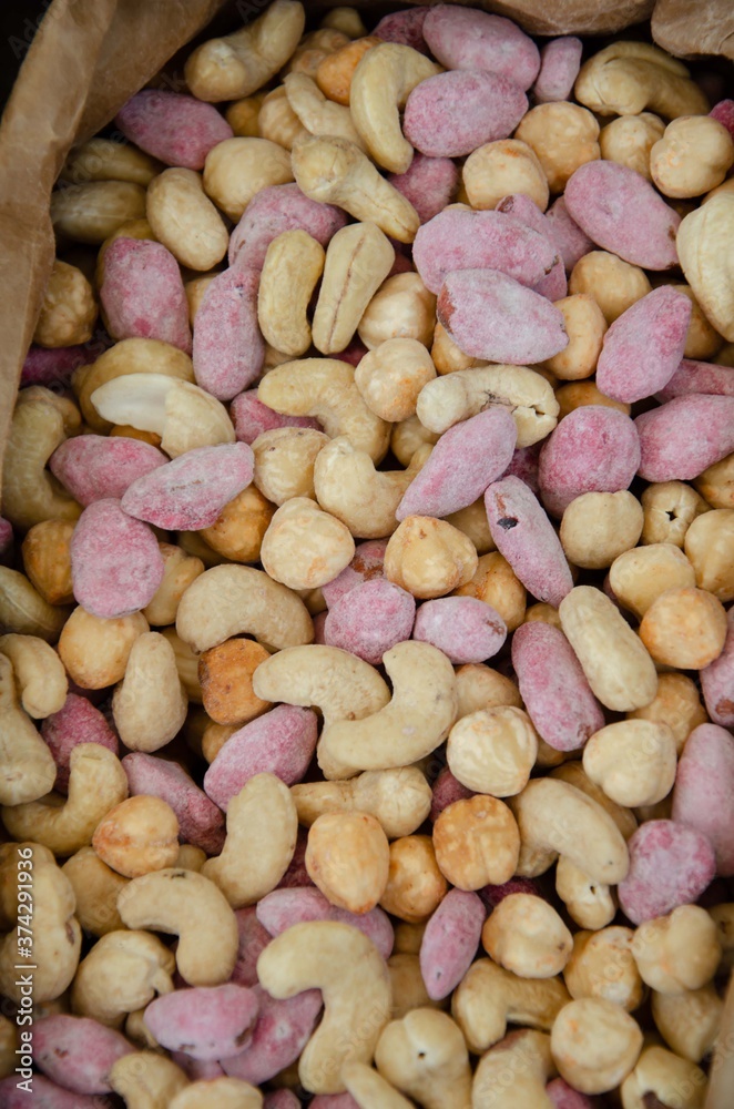 Colored nuts are covered with glaze. Lots of delicious nuts background.