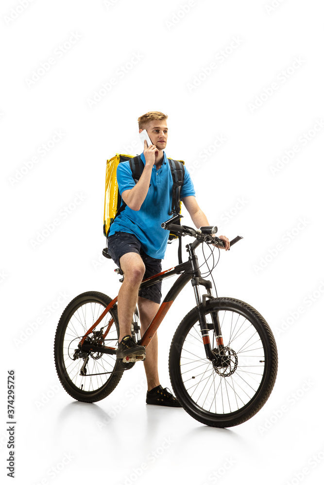 Taking order. Deliveryman with bicycle isolated on white studio background. Contacless service during quarantine. Man delivers food during isolation. Safety. Professional occupation. Copyspace for ad. Taking order. Deliveryman with bicycle isolated on white studio background. Contacless service during quarantine. Man delivers food during isolation. Safety. Professional occupation. Copyspace for ad.