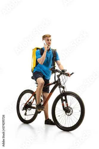 Taking order. Deliveryman with bicycle isolated on white studio background. Contacless service during quarantine. Man delivers food during isolation. Safety. Professional occupation. Copyspace for ad.