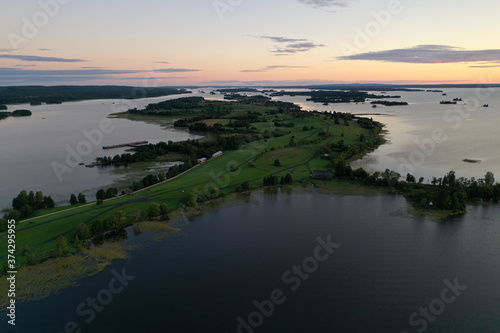panoramic view of the lake with many islands on one of them there is an ancient temple made of wood at sunset filmed from a drone © константин константи