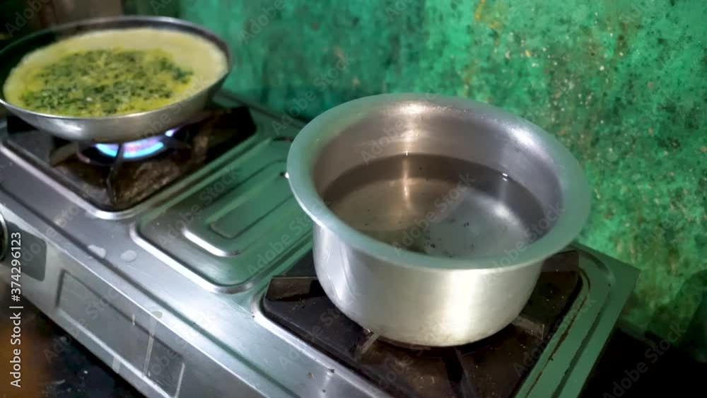 Opening The Stove Using Kitchen Gas Lighter And Place A Pot With Water. - Wide Shot Opening The Stove Using Kitchen Gas Lighter And Place A Pot With Water. - Wide Shot