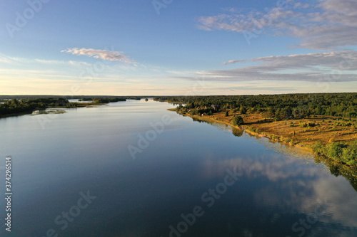 panoramic view of the lake with many islands on one of them there is an ancient temple made of wood at sunset filmed from a drone © константин константи