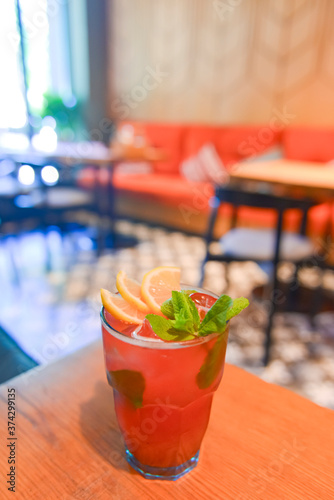 Red fruit cocktail drink with raspberry, mint and ice on dark rustic wooden table in a bar or restaurant. photo