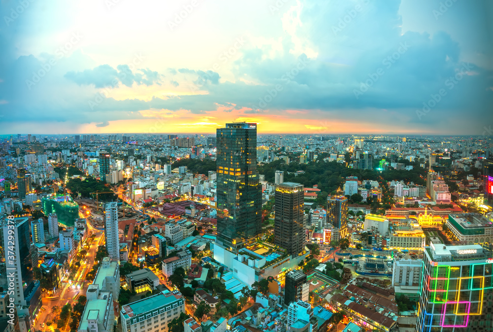 Fototapeta premium High view Saigon skyline when the sun shines down urban areas with tall buildings along the road show development country in Ho Chi Minh, Vietnam