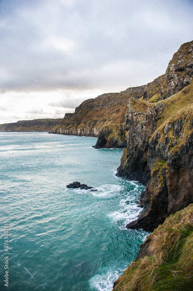 Scenic view over coastline and sea in the Northern Ireland in winter. Concepts: landscape, outdoor, tourism, travel Scenic view over coastline and sea in the Northern Ireland in winter. Concepts: landscape, outdoor, tourism, travel